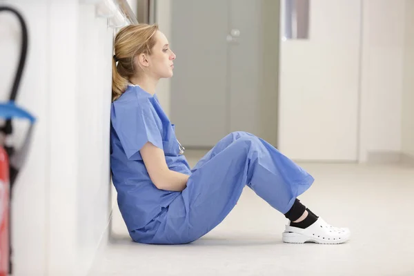 床に座っている動揺看護師 — ストック写真