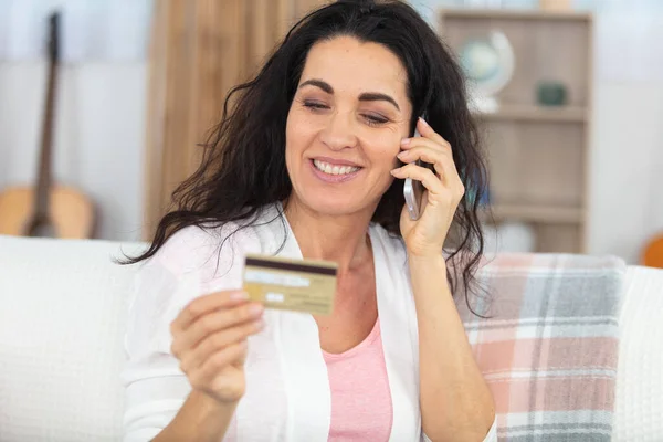 Ώριμη Γυναίκα Κρατώντας Πιστωτική Κάρτα Ενώ Μιλάμε Στο Κινητό Τηλέφωνο — Φωτογραφία Αρχείου