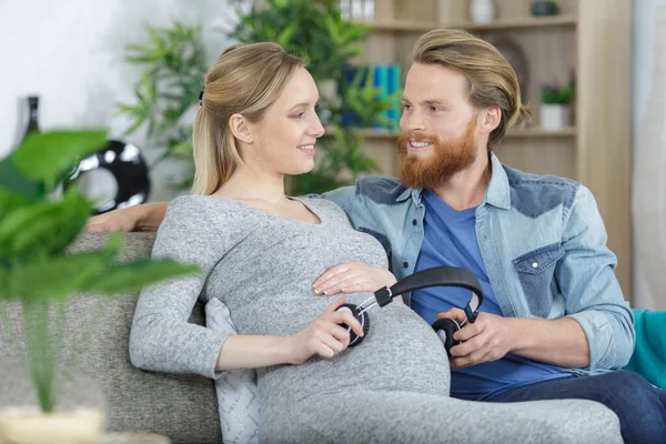 Hamile Kadın Yakışıklı Kocası Bebeğe Müzik Dinletiyor — Stok fotoğraf