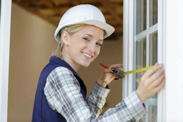 Pencereyi Ölçen Mutlu Bir Kadın Inşaatçı — Stok fotoğraf