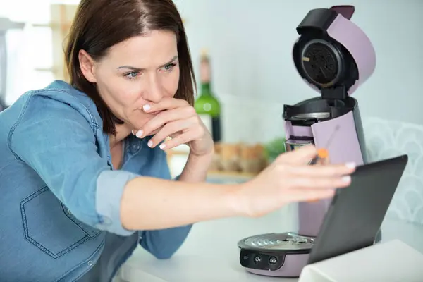 Γυναίκα Κοιτάζοντας Δισκίο Πώς Επισκευάσει Μηχανή Του Καφέ — Φωτογραφία Αρχείου