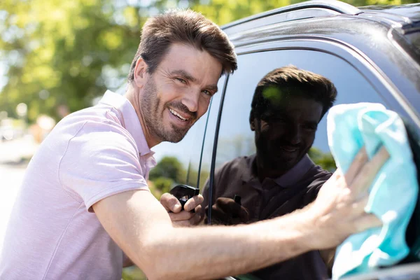 Portret Van Een Glimlachende Jongeman Die Zijn Auto Schoonmaakt — Stockfoto