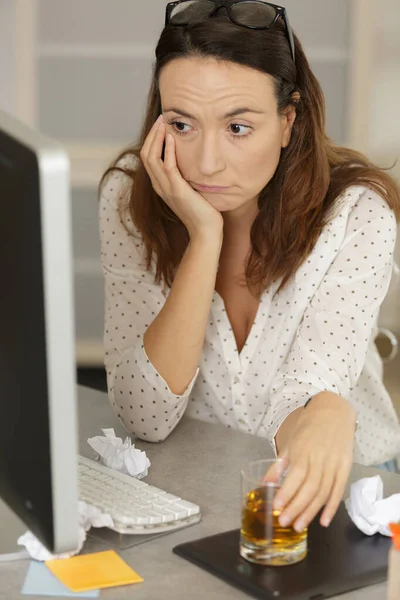 抑郁的女人一边喝酒一边用电脑 — 图库照片