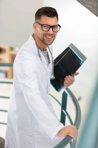 医生在医院里守着档案资料站在栏杆旁边 — 图库照片
