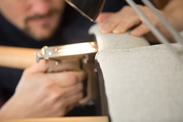 upholstery worker stapling furniture cover padding