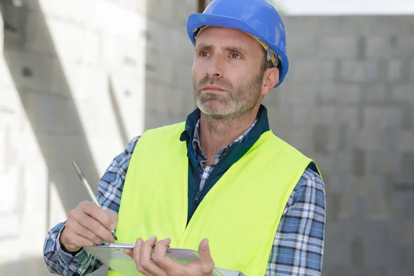 Male Builder Checking Clipboard — ストック写真