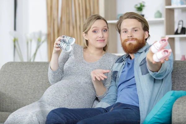 Lyckligt Par Som Visar Babyskor — Stockfoto