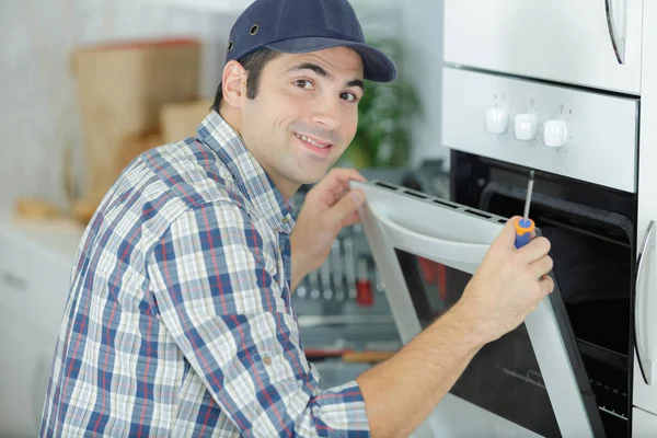 Handsome Repairman Fixing Oven Screwdriver — Stock Photo, Image