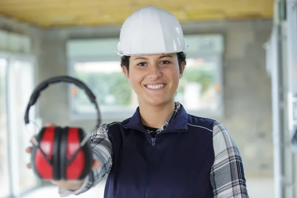 Trabalhador Construção Feminina Mostrando Fones Ouvido Protetores — Fotografia de Stock