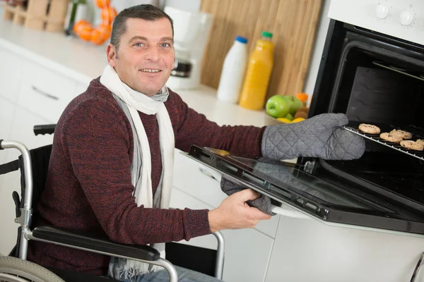 Positive Man Wheelchair Using Oven — Stock Photo, Image