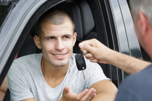 若い男に車の鍵を渡す先輩 — ストック写真