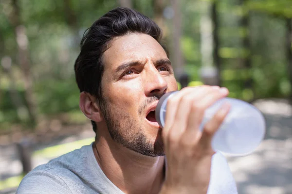 英俊的男人喝水在阳光明媚的一天 — 图库照片