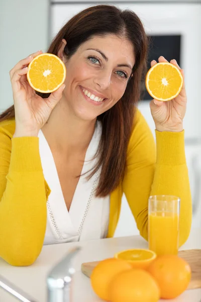 漂亮的女人手里拿着多汁的橙子 — 图库照片