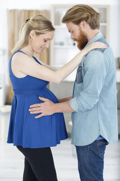 微笑的男人抱着妻子怀孕的肚子 — 图库照片