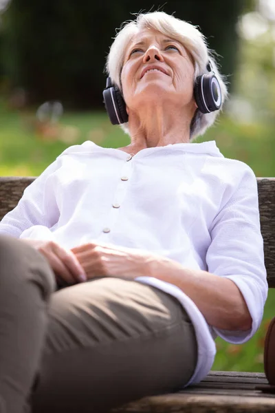 Старшая Женщина Сидящая Парке Слушает Музыку — стоковое фото