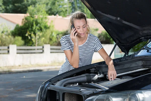壊れた車の近くで携帯電話を使っているストレスのある女性 — ストック写真