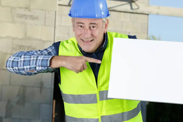 Ein Bauarbeiter Zeigt Auf Den Plan — Stockfoto