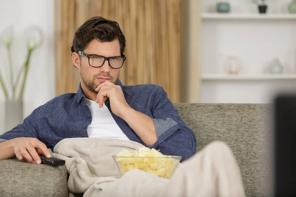 Άνθρωπος Τρώει Μάρκες Ενώ Βλέποντας Τηλεόραση Στο Σαλόνι — Φωτογραφία Αρχείου