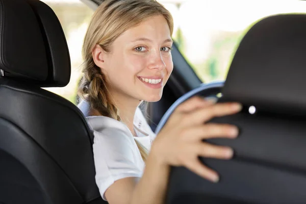 Młoda Kobieta Patrząc Wstecz Siedzenia Kierowcy Samochodu — Zdjęcie stockowe