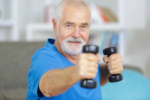 Bejaarde Man Die Thuis Met Dummbells Traint — Stockfoto