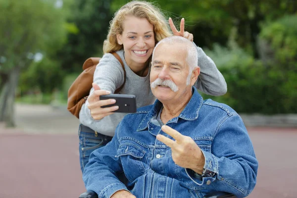 Ηλικιωμένος Άνδρας Και Νεαρή Γυναίκα Λήψη Selfie Κάνοντας Χειρονομία — Φωτογραφία Αρχείου