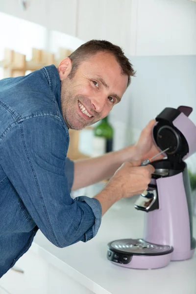 Улыбающийся Человек Ремонтирует Кофе Машину — стоковое фото