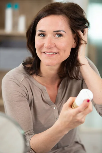 髪の毛を液体にしてスプレーするシニア女性 — ストック写真