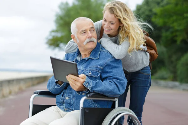 Tabletli Kız Yaşlı Adam Tekerlekli Sandalyede — Stok fotoğraf