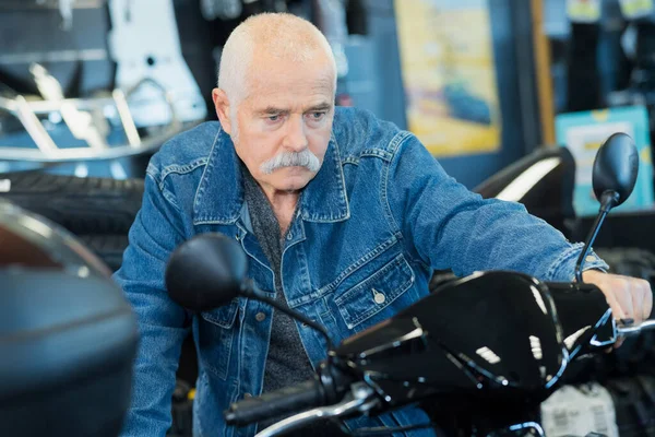 Starszy Mężczyzna Patrząc Cechy Motocykla — Zdjęcie stockowe