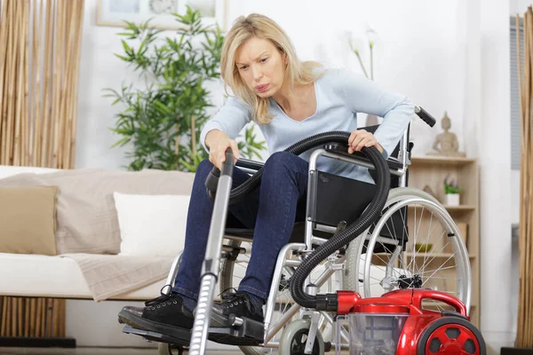 Ηλικιωμένη Γυναίκα Αναπηρική Καρέκλα Σκουπίζοντας Ένα Χαλί — Φωτογραφία Αρχείου