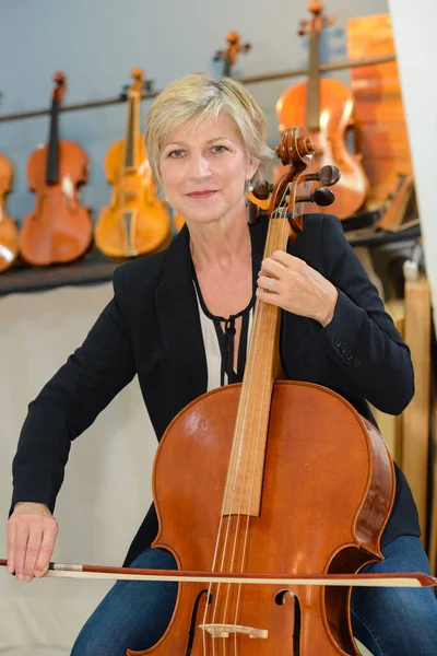 女歌手在乐器商店演奏大提琴的照片 — 图库照片