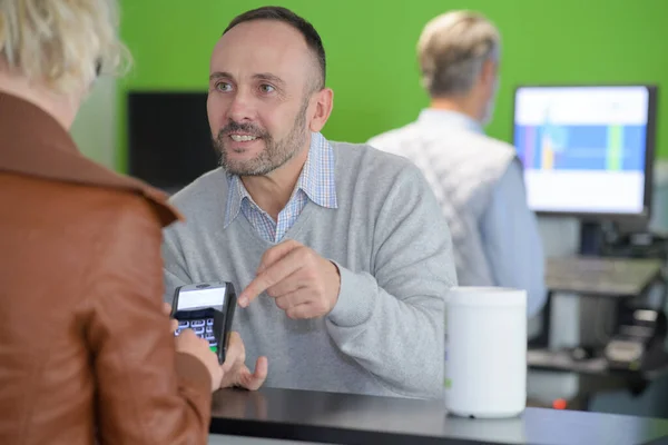 男人付钱给条例草案通过智能手机在咖啡馆里使用 Nfc — 图库照片