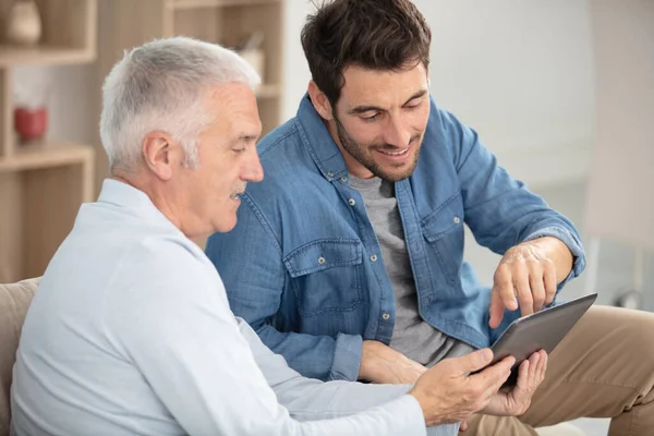 Senior Man Naast Zijn Zoon Met Behulp Van Tablet — Stockfoto