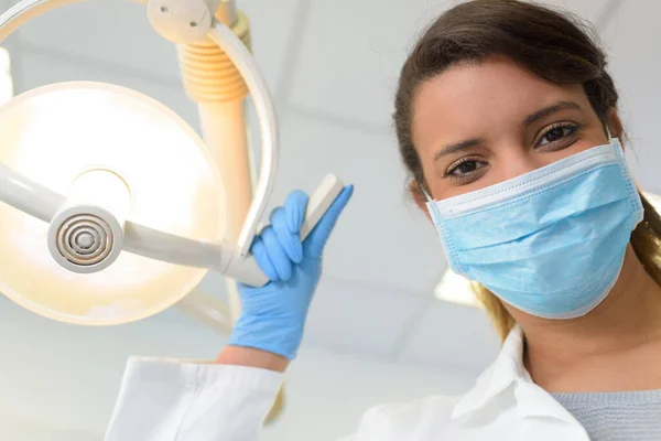 光を調節するマスクの女性歯科医の肖像画 — ストック写真