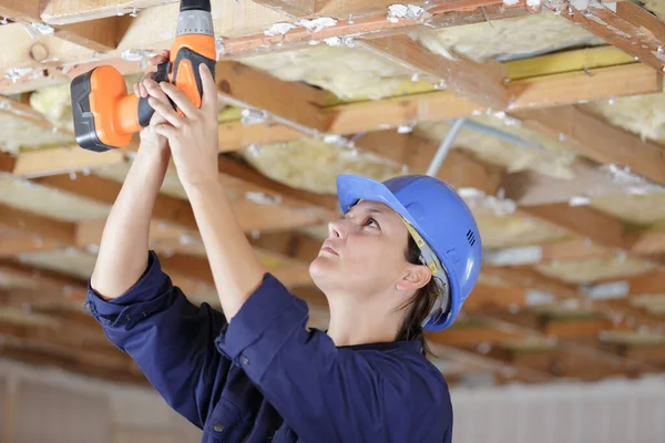 Vrouwelijke Bouwer Met Accuboor Plafondbalken — Stockfoto
