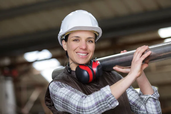 配管を保持する工事現場で配管工の女性 — ストック写真