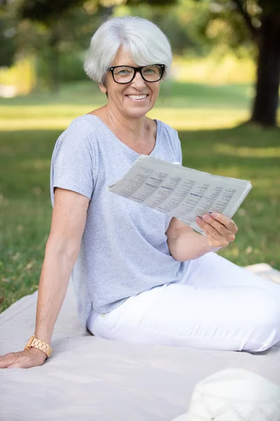 Χαρούμενη Ηλικιωμένη Κυρία Χαλαρώνοντας Στο Πάρκο Διαβάζοντας Εφημερίδα — Φωτογραφία Αρχείου