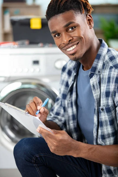 食器洗い機の近くに座る男性技術者 — ストック写真
