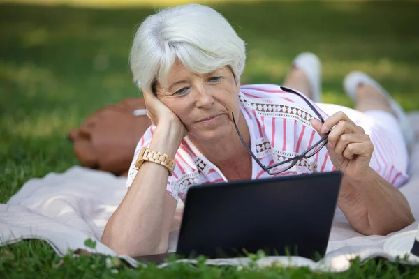 Senior Kvinna Sitter Gräsmattan Arbetar Avslappnad Med Laptop — Stockfoto