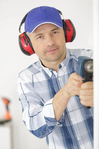 Man Protective Ear Muffs Drilling Hole Wall — Stock Photo, Image