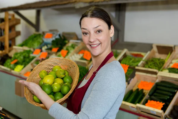 Vrouwelijke Groenteboer Bedrijf Mand Van Limoenen — Stockfoto