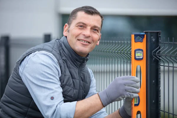 Man Checks Level New Fence Gates — Stock Photo, Image