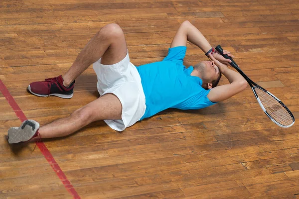 网球比赛后失望的年轻人躺在地板上 — 图库照片