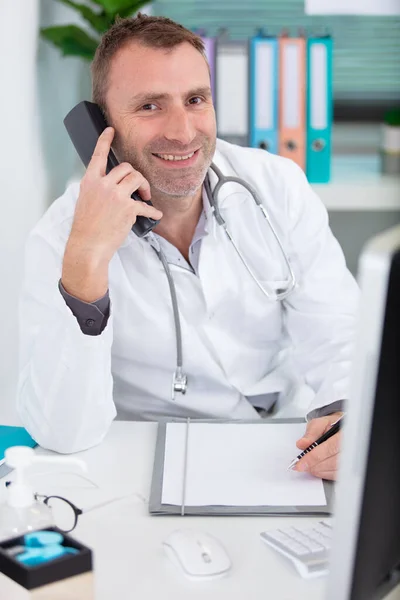 Γιατρός Στο Γραφείο Του Μιλάει Στο Τηλέφωνο — Φωτογραφία Αρχείου