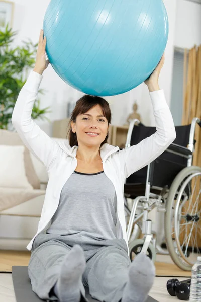 Mulher Exercícios Com Uma Bola Azul Casa — Fotografia de Stock
