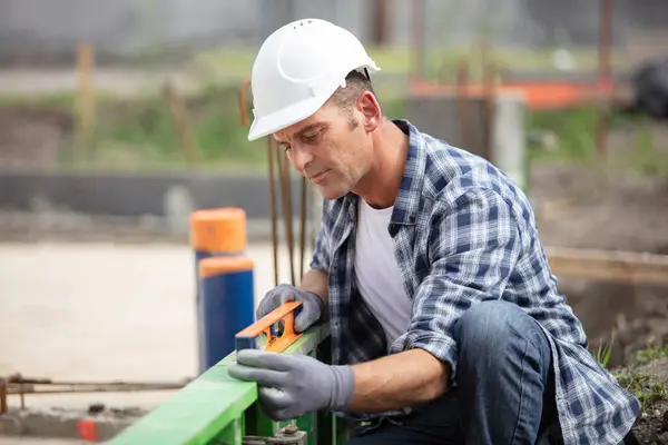 Bauarbeiter Mit Wasserwaage Auf Baustelle — Stockfoto