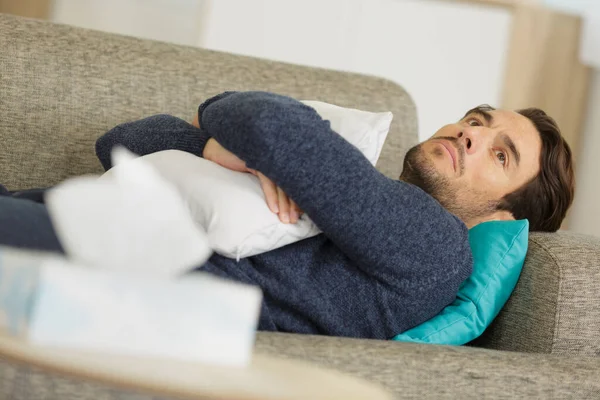 Dalgın Bir Adam Kanepeye Uzanmış Elinde Yastıkla — Stok fotoğraf