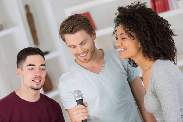 Tři Mladí Lidé Stáli Zpívali Kolem Mikrofonu — Stock fotografie