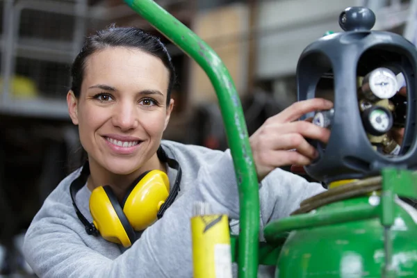 ガスの瓶の横で働く女性の笑顔は — ストック写真