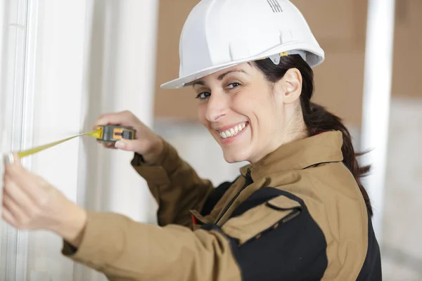 Kvinnlig Byggare Kontrollerar Mätningar — Stockfoto